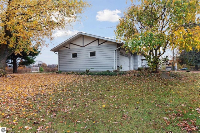 view of side of home with a garage and a lawn