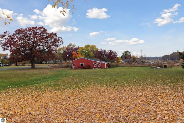 view of yard with an outdoor structure and a rural view