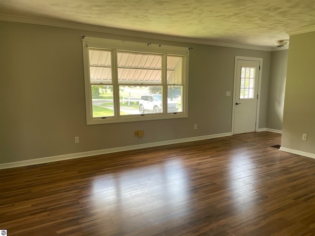 spare room with dark wood-type flooring and ornamental molding