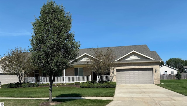 view of front of property with a garage, a front lawn, and covered porch