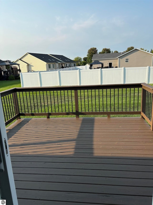 wooden terrace featuring a lawn