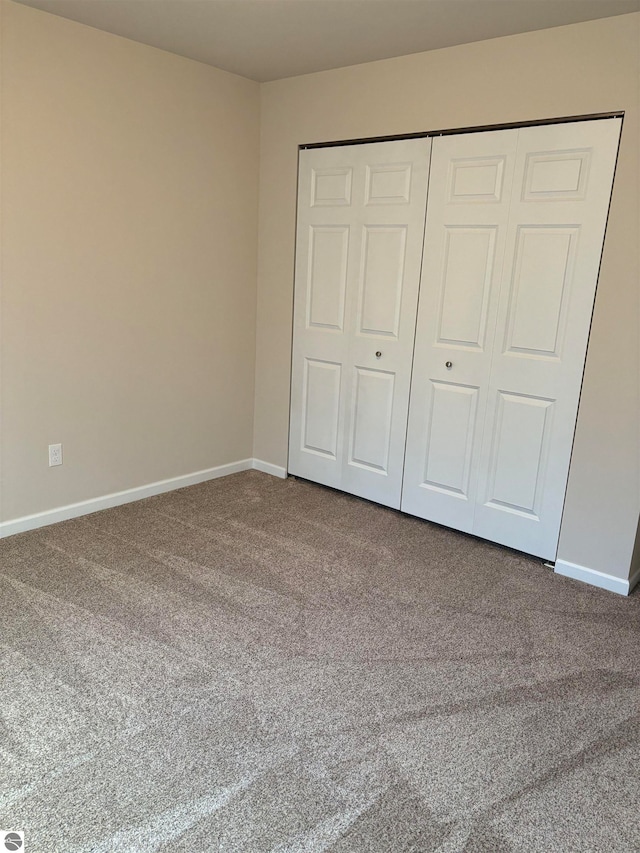 unfurnished bedroom with a closet and carpet floors