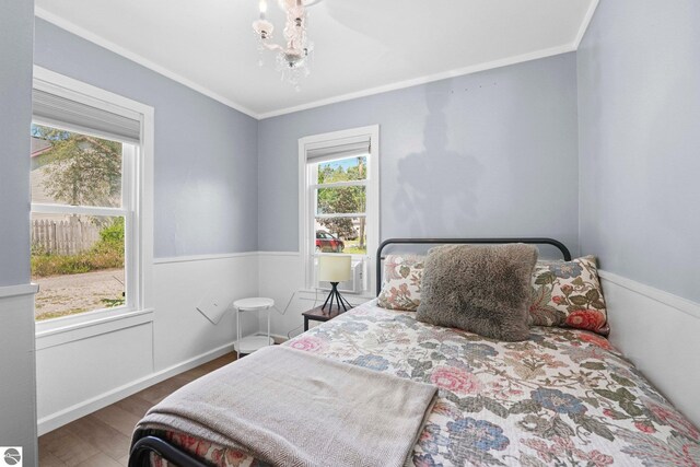 bedroom featuring crown molding, multiple windows, dark hardwood / wood-style flooring, and a chandelier