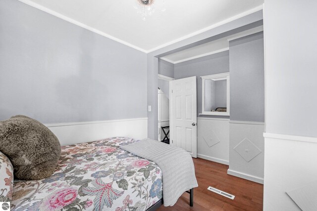 bedroom with crown molding and wood-type flooring