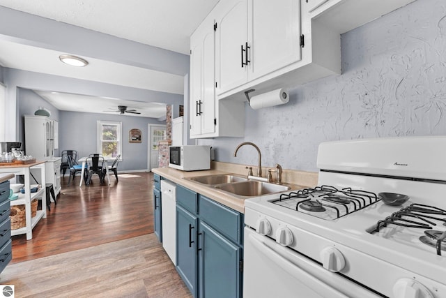 kitchen featuring light wood-type flooring, white appliances, white cabinetry, sink, and ceiling fan