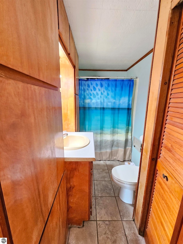 bathroom with tile patterned floors, walk in shower, toilet, and vanity