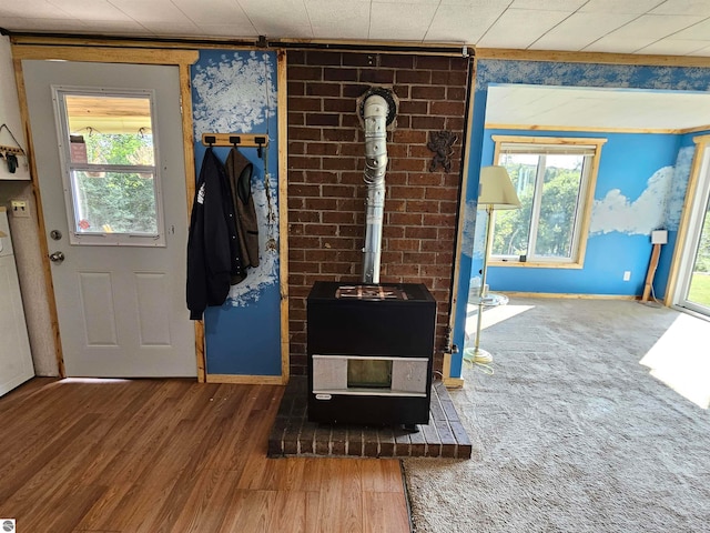 details featuring a wood stove, ornamental molding, and hardwood / wood-style floors