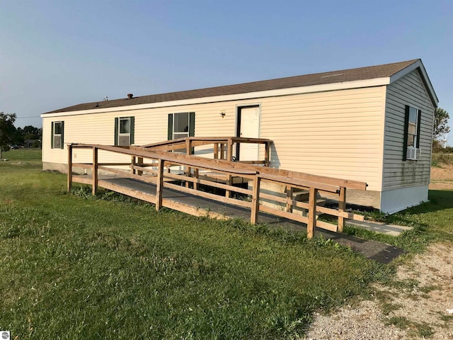 rear view of house featuring cooling unit and a lawn