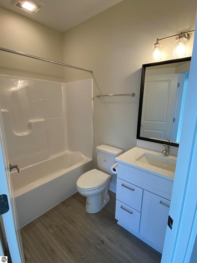 full bathroom featuring vanity, hardwood / wood-style floors, shower / washtub combination, and toilet