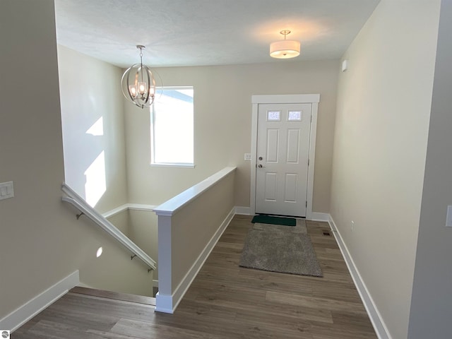 foyer entrance with hardwood / wood-style flooring and a chandelier