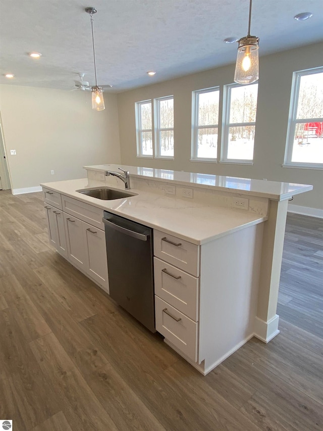 kitchen with a healthy amount of sunlight, sink, dishwasher, pendant lighting, and white cabinets