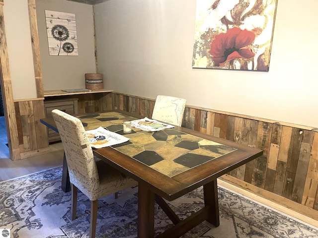 dining area featuring wood walls and wainscoting