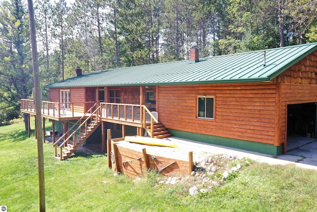 view of front of home featuring a chimney, stairway, a front yard, a standing seam roof, and metal roof