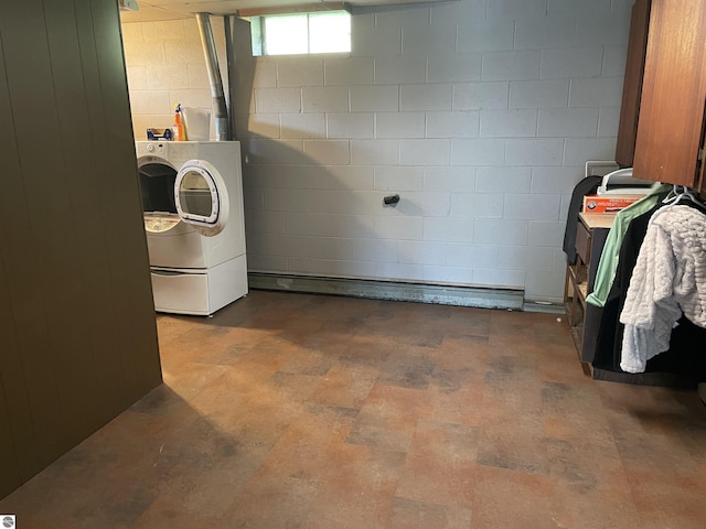 laundry room featuring concrete block wall, laundry area, and separate washer and dryer