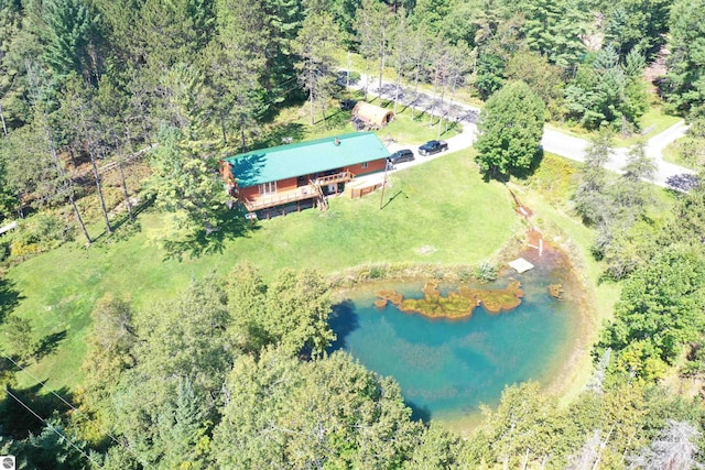 birds eye view of property featuring a water view and a view of trees