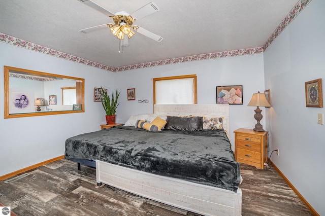 bedroom featuring a textured ceiling, dark wood-type flooring, and ceiling fan