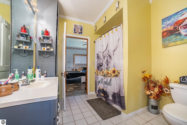 bathroom with a textured ceiling, vanity, toilet, ornamental molding, and tile patterned floors