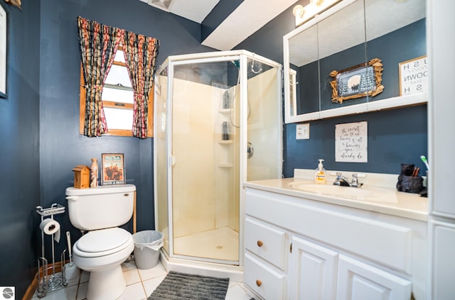 bathroom with a textured ceiling, vanity, a shower with shower door, tile patterned flooring, and toilet