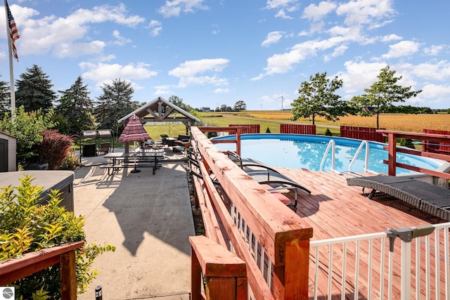 view of swimming pool featuring a yard, a rural view, and a patio