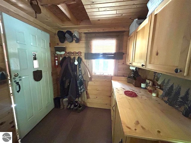 kitchen with wood ceiling, light brown cabinets, and wooden walls