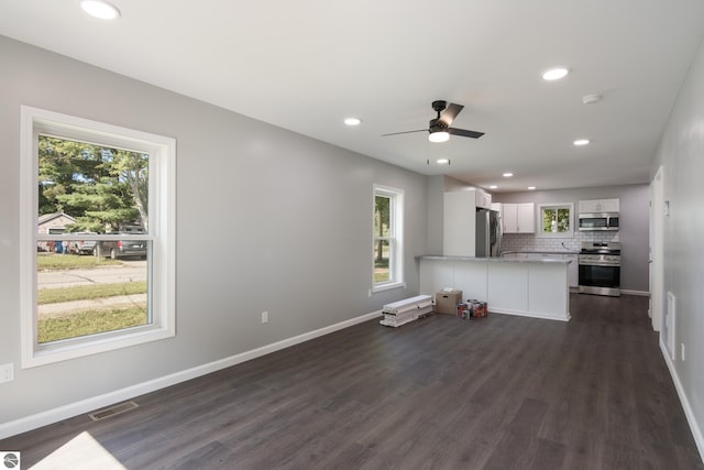 unfurnished living room with ceiling fan and dark hardwood / wood-style floors