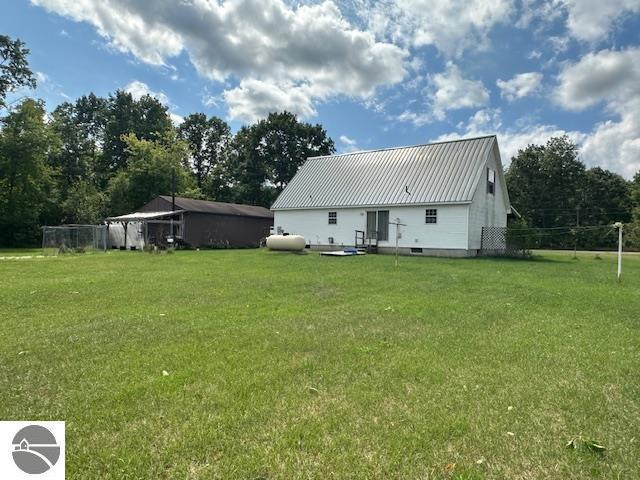 rear view of property featuring a lawn, metal roof, and a standing seam roof