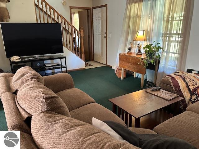 carpeted living room featuring stairway