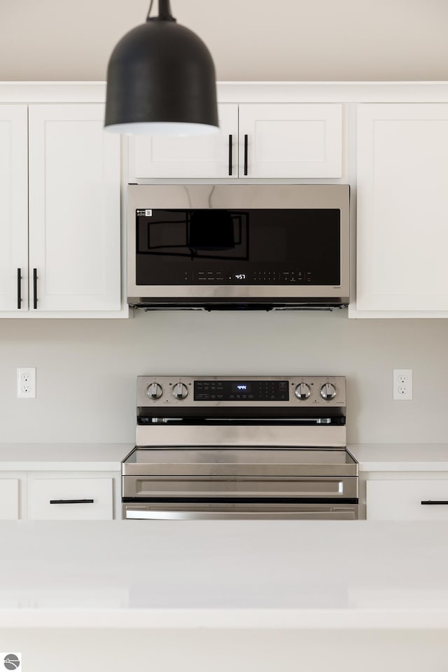 details with white cabinets, appliances with stainless steel finishes, and light countertops