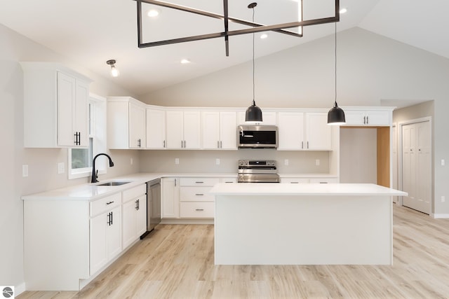 kitchen featuring a kitchen island, a sink, white cabinets, light countertops, and appliances with stainless steel finishes