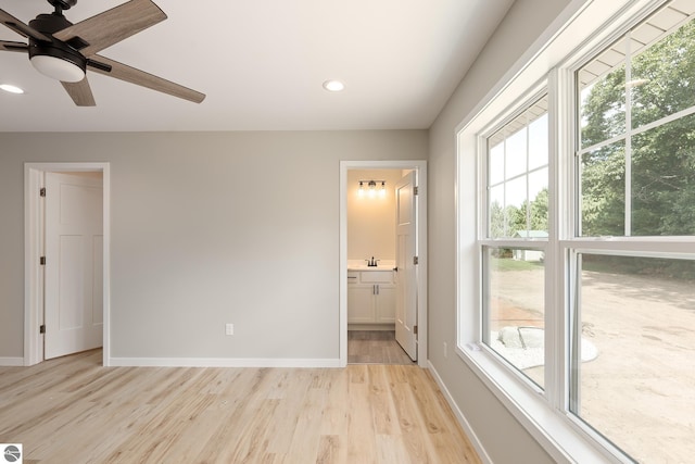 interior space featuring recessed lighting, a sink, light wood-style flooring, and baseboards