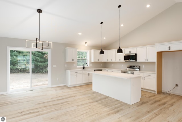 kitchen featuring hanging light fixtures, stainless steel appliances, sink, high vaulted ceiling, and white cabinetry