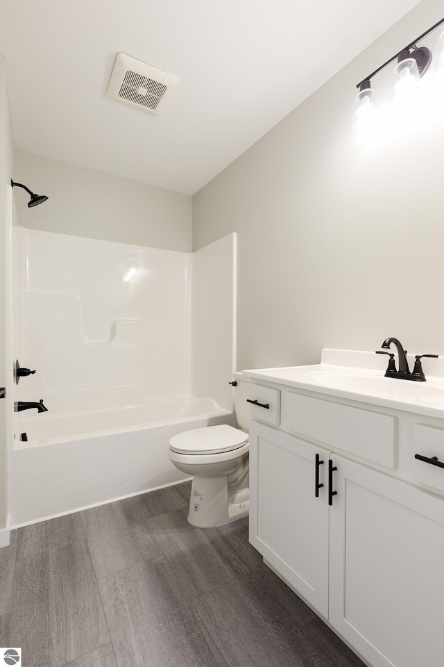 bathroom featuring bathtub / shower combination, visible vents, toilet, vanity, and wood finished floors