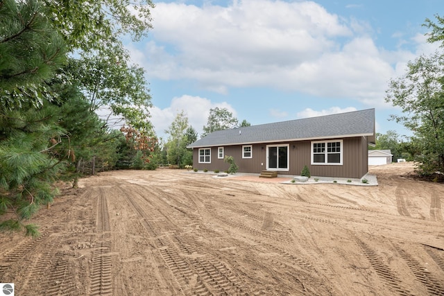 back of property featuring dirt driveway