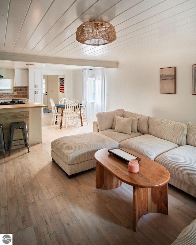 living room featuring wood ceiling, a notable chandelier, and light wood-type flooring