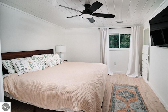 bedroom featuring ceiling fan, ornamental molding, and light wood-type flooring