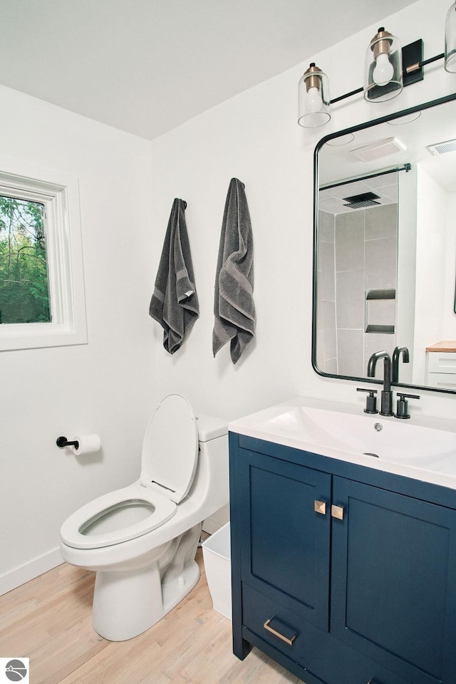 bathroom with vanity, toilet, and wood-type flooring