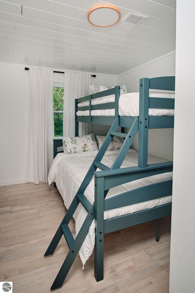 bedroom featuring light wood-type flooring and ornamental molding