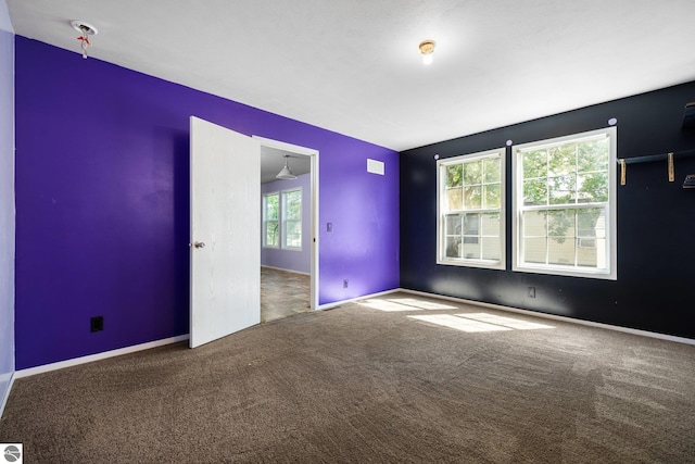 carpeted empty room with ceiling fan and plenty of natural light