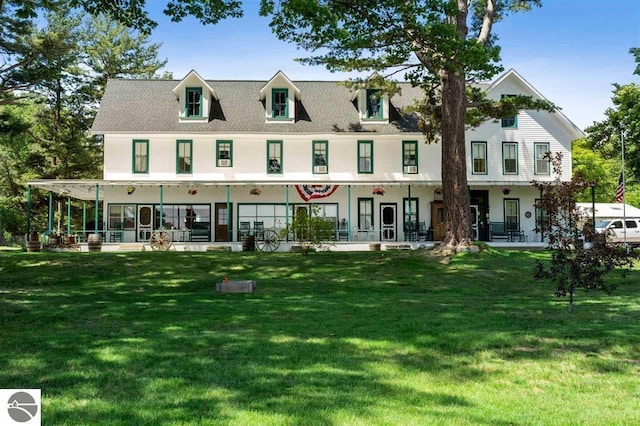 rear view of house with a yard and a porch