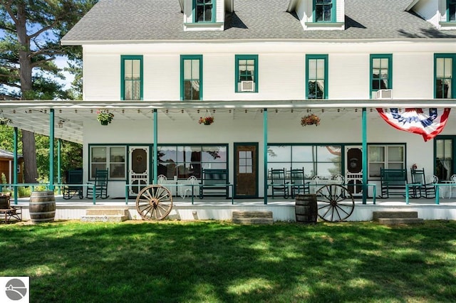 rear view of property with a yard and a porch