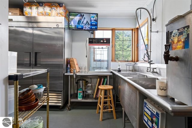 kitchen with built in fridge and concrete flooring