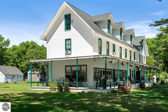 rear view of house with a porch, a yard, and cooling unit