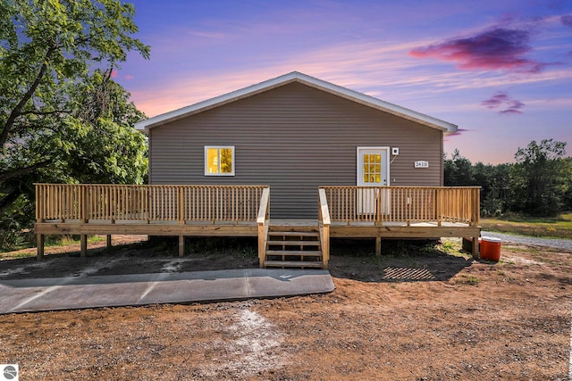 back house at dusk featuring a wooden deck