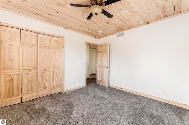 unfurnished bedroom with a closet, ceiling fan, wooden ceiling, and carpet floors