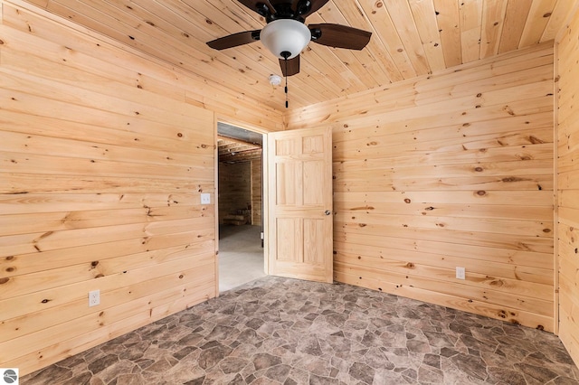 empty room with wood walls, ceiling fan, and wood ceiling