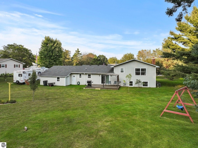 rear view of house with a wooden deck and a yard