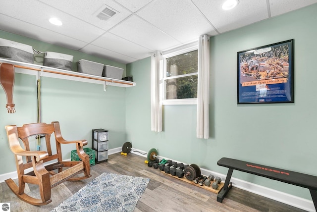 living area with a paneled ceiling and hardwood / wood-style floors