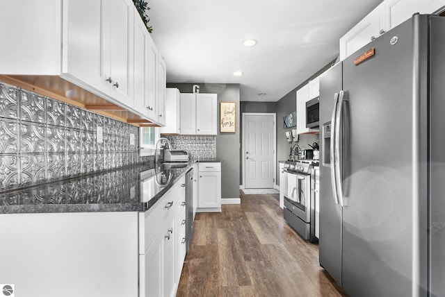 kitchen with stainless steel appliances, white cabinetry, dark hardwood / wood-style floors, and sink