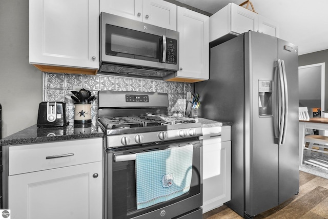 kitchen with hardwood / wood-style flooring, appliances with stainless steel finishes, backsplash, and white cabinetry