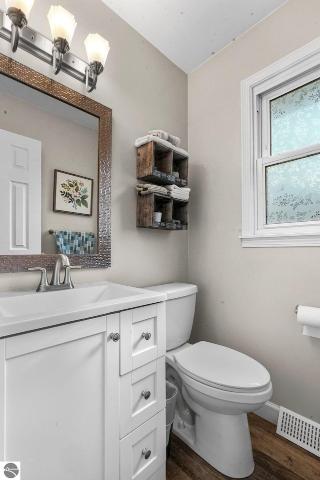 bathroom featuring wood-type flooring, vanity, and toilet